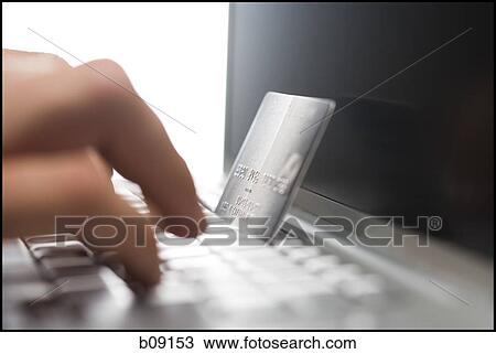Close-up of a person's hand using a laptop and a credit card for online shopping View Large Photo Image Stock Image - Close-up of a person's hand using a laptop and a credit card for online shopping. Fotosearch
