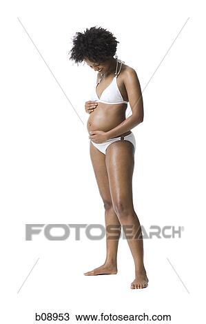 Close-up of a pregnant woman touching her abdomen View Large Photo Image Stock Image - Close-up of a pregnant woman touching her abdomen. Fotosearch