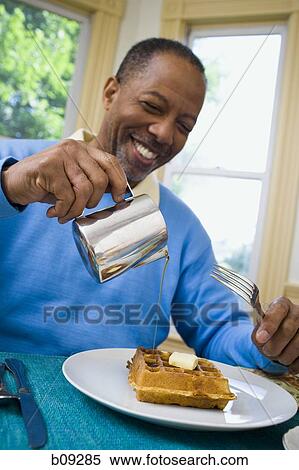 Close-up of a senior man pouring syrup on his waffle View Large Photo Image Stock Photography - Close-up of a senior man pouring syrup on his waffle. Fotosearch