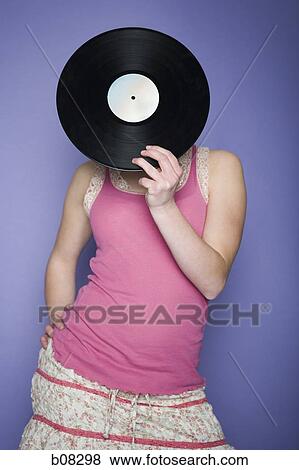 Close-up of a teenage girl covering her face with a record View Large Photo Image Stock Photo - Close-up of a teenage girl covering her face with a record. Fotosearch
