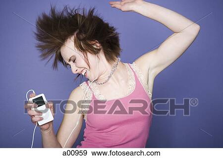 Close-up of a teenage girl listening to an MP3 player View Large Photo Image Stock Photo - Close-up of a teenage girl listening to an MP3 player. Fotosearch