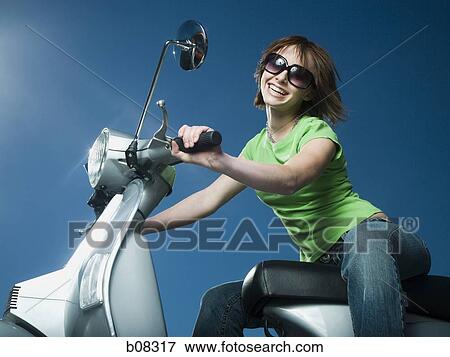 Close-up of a teenage girl riding a scooter View Large Photo Image Stock Photo - Close-up of a teenage girl riding a scooter. Fotosearch