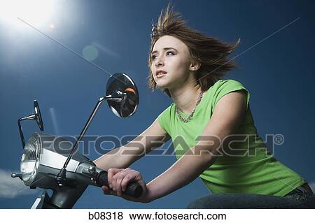 Close-up of a teenage girl riding a scooter View Large Photo Image Stock Photo - Close-up of a teenage girl riding a scooter. Fotosearch