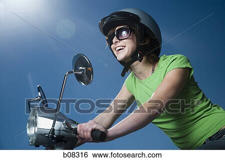 Close-up of a teenage girl riding a scooter View Large Photo Image Stock Photograph - Close-up of a teenage girl riding a scooter. Fotosearch