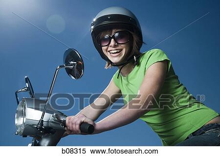 Stock Photography - Close-up of a teenage girl riding a scooter. Fotosearch