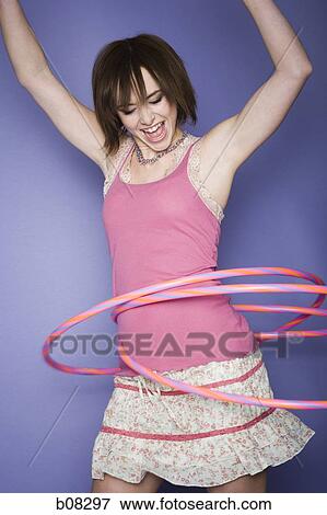 Close-up of a teenage girl spinning hula hoops around his waist View Large Photo Image Stock Photo - Close-up of a teenage girl spinning hula hoops around his waist. Fotosearch
