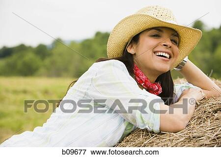 Close-up of a woman lying on a hay bale View Large Photo Image Stock Photo - Close-up of a woman lying on a hay bale. Fotosearch
