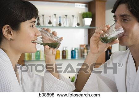 Close-up of a young couple drinking wheatgrass juice View Large Photo Image Stock Photo - Close-up of a young couple drinking wheatgrass juice. Fotosearch