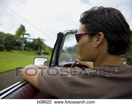 Close-up of a young man driving a car View Large Photo Image Stock Image - Close-up of a young man driving a car. Fotosearch
