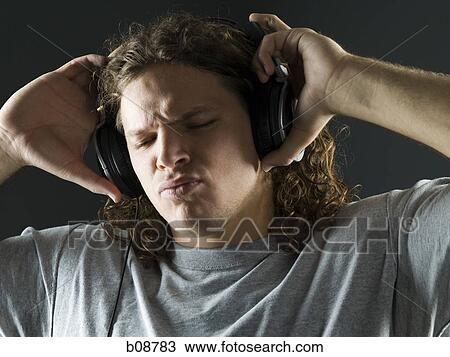 Close-up of a young man listening to the music on headphones View Large Photo Image Stock Image - Close-up of a young man listening to the music on headphones. Fotosearch