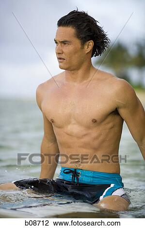 Close-up of a young man sitting on a surfboard View Large Photo Image Stock Image - Close-up of a young man sitting on a surfboard. Fotosearch