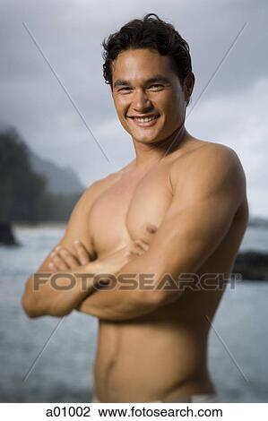 Close-up of a young man standing with his arms crossed View Large Photo Image Stock Image - Close-up of a young man standing with his arms crossed. Fotosearch