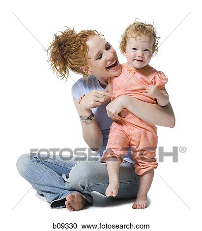 Stock Image - Close-up of a young woman and her daughter smiling. Fotosearch