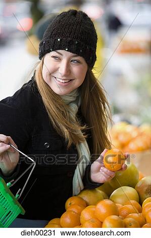 Close-up of a young woman buying oranges View Large Photo Image Stock Image - Close-up of a young woman buying oranges. Fotosearch