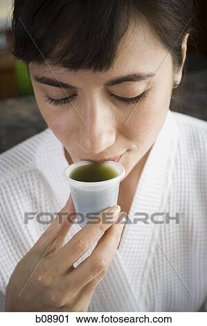 Close-up of a young woman drinking wheatgrass juice View Large Photo Image Stock Image - Close-up of a young woman drinking wheatgrass juice. Fotosearch