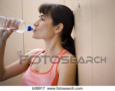 Close-up of a young woman drinking water from a water bottle View Large Photo Image Stock Photo - Close-up of a young woman drinking water from a water bottle. Fotosearch