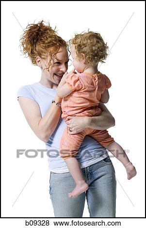 Close-up of a young woman holding her daughter View Large Photo Image Stock Photo - Close-up of a young woman holding her daughter. Fotosearch