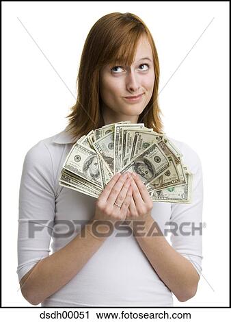 Close-up of a young woman holding fanned out dollar bills and looking up View Large Photo Image Stock Image - Close-up of a young woman holding fanned out dollar bills and looking up. Fotosearch