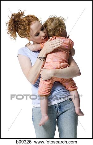 Close-up of a young woman hugging her daughter View Large Photo Image Stock Photograph - Close-up of a young woman hugging her daughter. Fotosearch