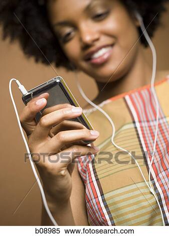 Close-up of a young woman listening an MP3 player View Large Photo Image Stock Photography - Close-up of a young woman listening an MP3 player. Fotosearch