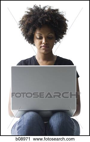 Close-up of a young woman using a laptop View Large Photo Image Stock Image - Close-up of a young woman using a laptop. Fotosearch