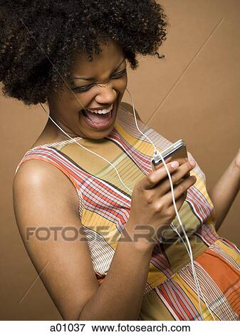 Close-up of a young woman watching a video MP3 player View Large Photo Image Stock Photo - Close-up of a young woman watching a video MP3 player. Fotosearch