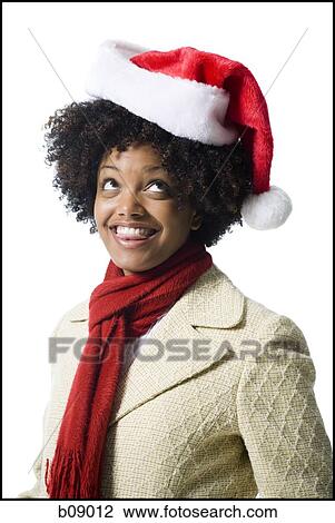 Close-up of a young woman wearing a Santa hat View Large Photo Image Stock Image - Close-up of a young woman wearing a Santa hat. Fotosearch