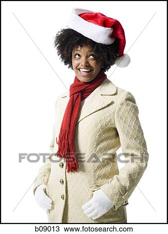Stock Image - Close-up of a young woman wearing a Santa hat. Fotosearch