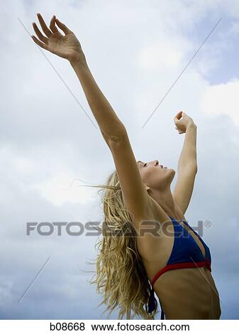 Close-up of a young woman with her arms raised View Large Photo Image Stock Photo - Close-up of a young woman with her arms raised. Fotosearch