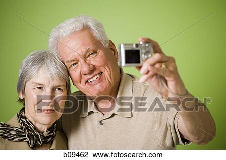 Close-up of an elderly couple taking a photograph of themselves View Large Photo Image Stock Image - Close-up of an elderly couple taking a photograph of themselves. Fotosearch