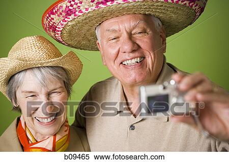 Close-up of an elderly couple taking a photograph of themselves View Large Photo Image Stock Photography - Close-up of an elderly couple taking a photograph of themselves. Fotosearch