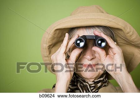 Close-up of an elderly woman looking through a pair of binoculars View Large Photo Image Picture - Close-up of an elderly woman looking through a pair of binoculars. Fotosearch