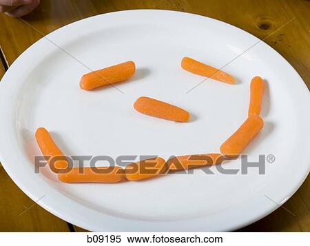 Close-up of baby carrots arranged in the shape of a smiling face in a plate View Large Photo Image Stock Photography - Close-up of baby carrots arranged in the shape of a smiling face in a plate. Fotosearch