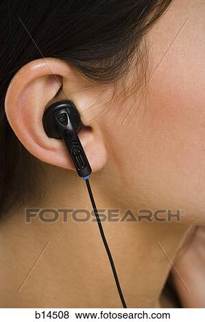 Closeup of female ear with earbud View Large Photo Image Stock Photo - Closeup of female ear with earbud. Fotosearch