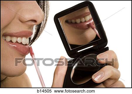 Closeup of woman applying lipstick with compact mirror View Large Photo Image Stock Photography - Closeup of woman applying lipstick with compact mirror. Fotosearch