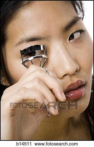 Closeup of woman curling eyelashes View Large Photo Image Stock Image - Closeup of woman curling eyelashes. Fotosearch