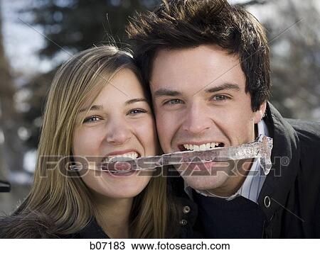 Couple biting an icicle View Large Photo Image Stock Image - Couple biting an icicle. Fotosearch