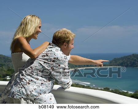 Couple by railing overlooking ocean View Large Photo Image Stock Photo - Couple by railing overlooking ocean. Fotosearch