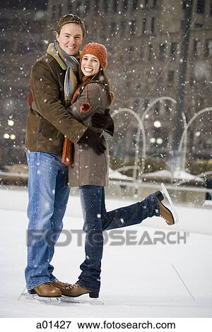 Couple embracing outdoors in winter with ice skates View Large Photo Image Stock Photo - Couple embracing outdoors in winter with ice skates. Fotosearch