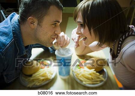 Couple on a date eating hamburgers View Large Photo Image Stock Photograph - Couple on a date eating hamburgers. Fotosearch