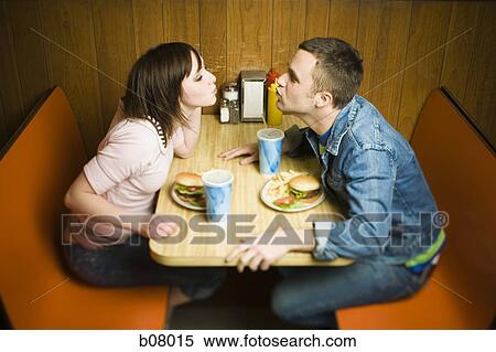 Couple on a date eating hamburgers View Large Photo Image Stock Photography - Couple on a date eating hamburgers. Fotosearch