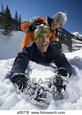 Couple playing in the snow View Large Photo Image Stock Photograph - Couple playing in the snow. Fotosearch