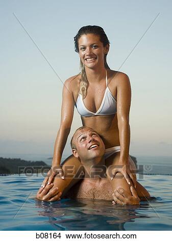 Couple relaxing in infinity pool View Large Photo Image Picture - Couple relaxing in infinity pool. Fotosearch