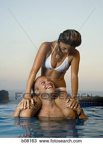 Couple relaxing in infinity pool View Large Photo Image Stock Image - Couple relaxing in infinity pool. Fotosearch