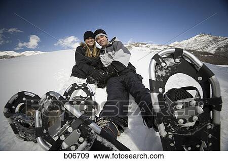 Stock Photo - Couple resting with snow shoes. Fotosearch