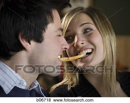 Couple sharing a french fry View Large Photo Image Stock Photo - Couple sharing a french fry. Fotosearch