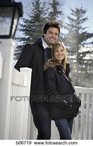 Couple smiling standing near fence View Large Photo Image Stock Photo - Couple smiling standing near fence. Fotosearch