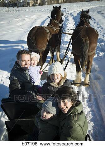 Family riding in horse drawn sleigh View Large Photo Image Stock Photograph - Family riding in horse drawn sleigh. Fotosearch