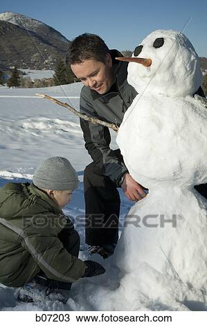 Father and son making snowman View Large Photo Image Stock Image - Father and son making snowman. Fotosearch