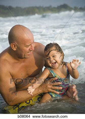 Picture - Father playing with young daughter at beach. Fotosearch